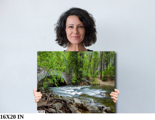 A woman holding up a picture of a river.