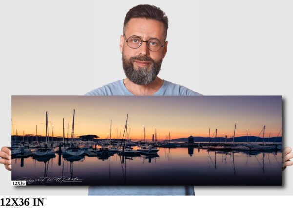A man is holding up a picture of boats in the water.