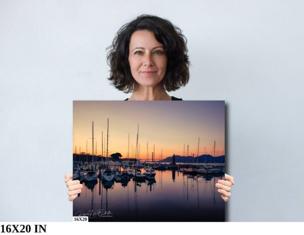 A woman holding up a picture of boats in the water.