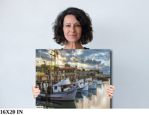 A woman holding up a picture of boats in the water.