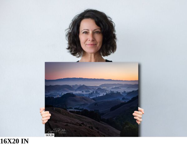 A woman holding up a picture of mountains