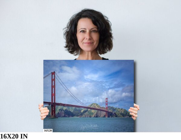 A woman holding up a picture of the golden gate bridge.