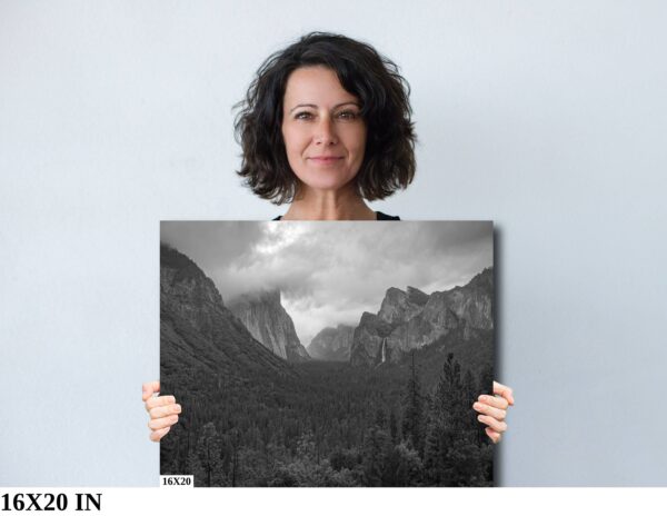 A woman holding up a picture of mountains