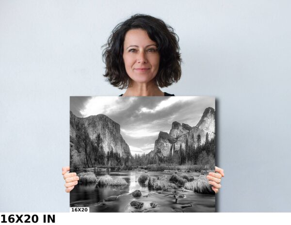 A woman holding up a picture of mountains and water.
