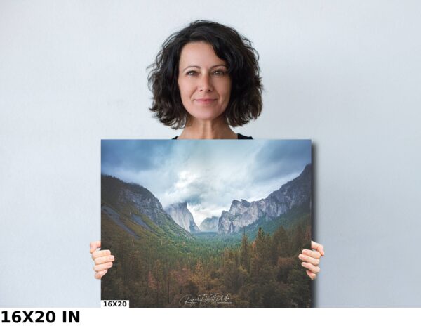 A woman holding up a picture of the mountains.