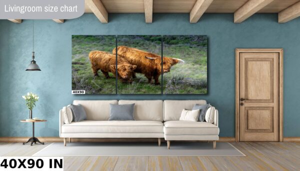 A living room with couch and sofa, and three pictures of two bulls.