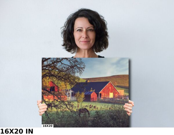 A woman holding up a picture of a barn.
