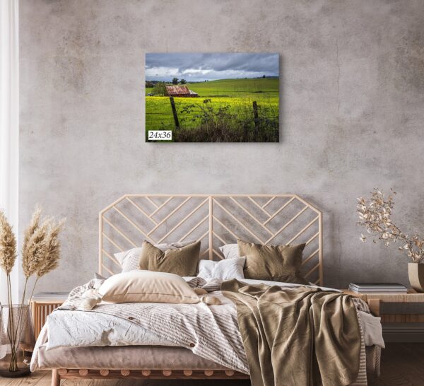 A bed room with a painting of a farm