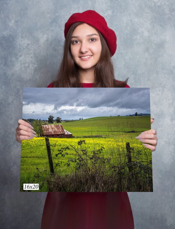 A girl holding up a picture of a field.