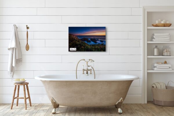 A bathtub with a painting on the wall above it