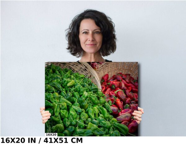 A woman holding up a picture of peppers and apples.
