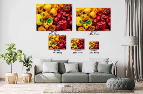 A couch with pillows and a wall hanging of peppers