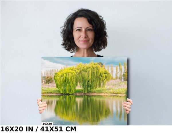 A woman holding up a painting of trees