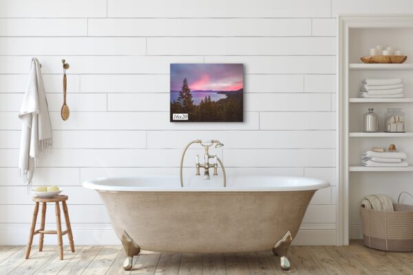 A bathtub with a painting on the wall above it