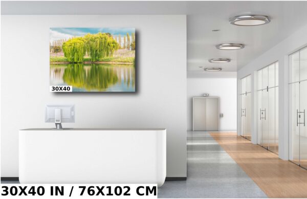 A large painting of trees in front of water