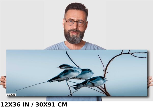 A man standing next to a tree with three birds on it.