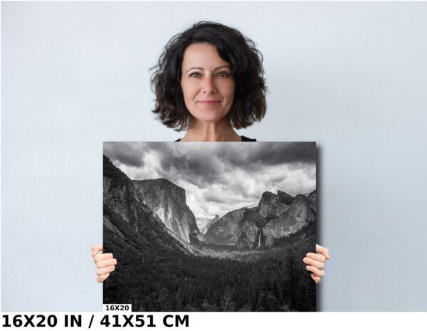 A woman holding up an image of mountains.