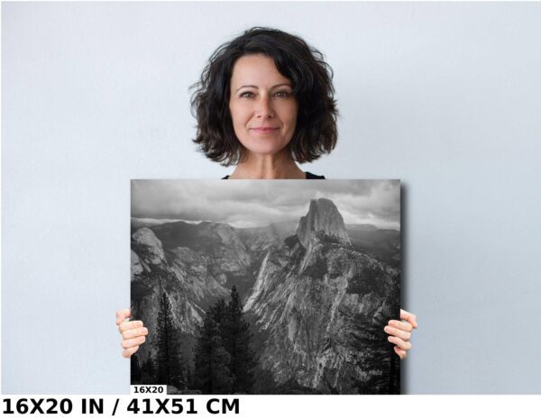 A woman holding up a picture of mountains