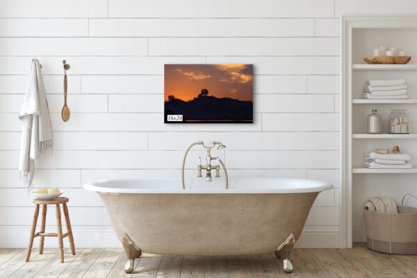 A bathtub with a picture hanging on the wall