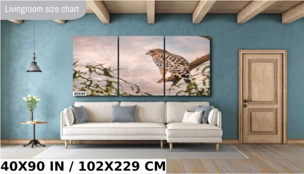 A large painting of a hawk sitting on a branch.