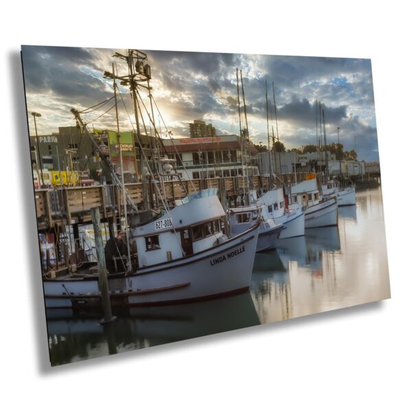 A group of boats in the water at sunset.