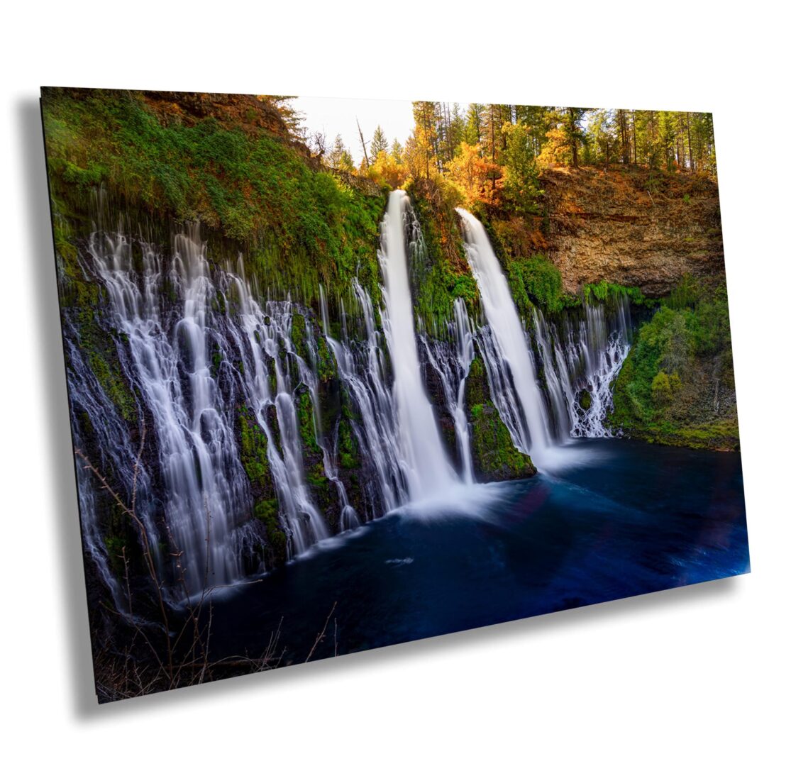 A picture of two waterfalls in the middle of a forest.