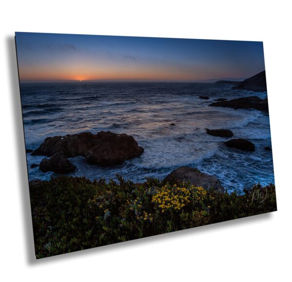 A picture of the ocean at sunset with rocks in front.