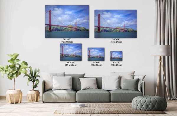 A living room with couch and pillows, and two paintings of the golden gate bridge.
