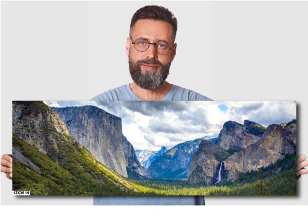A man is holding up a picture of mountains.