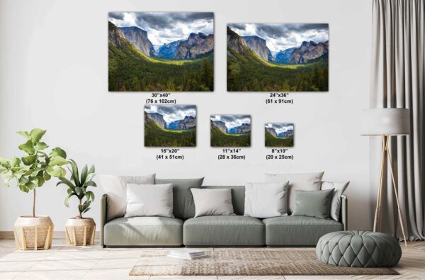 A couch with pillows and two pictures of mountains