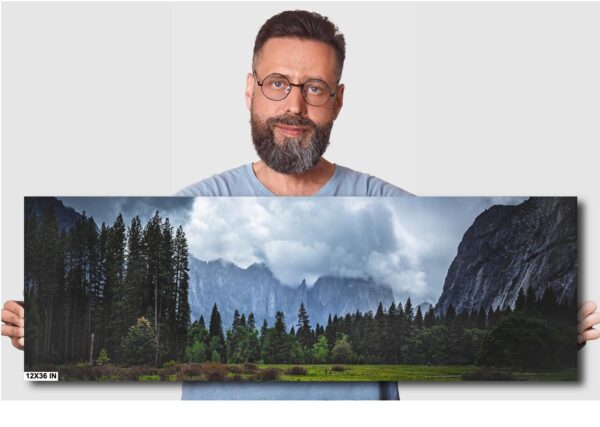 A man holding up a picture of the mountains.