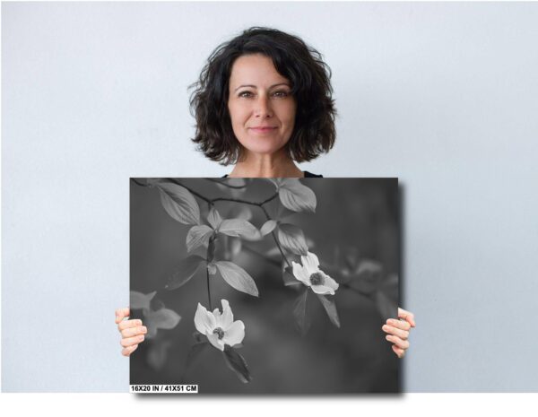 A woman holding up a picture of flowers.