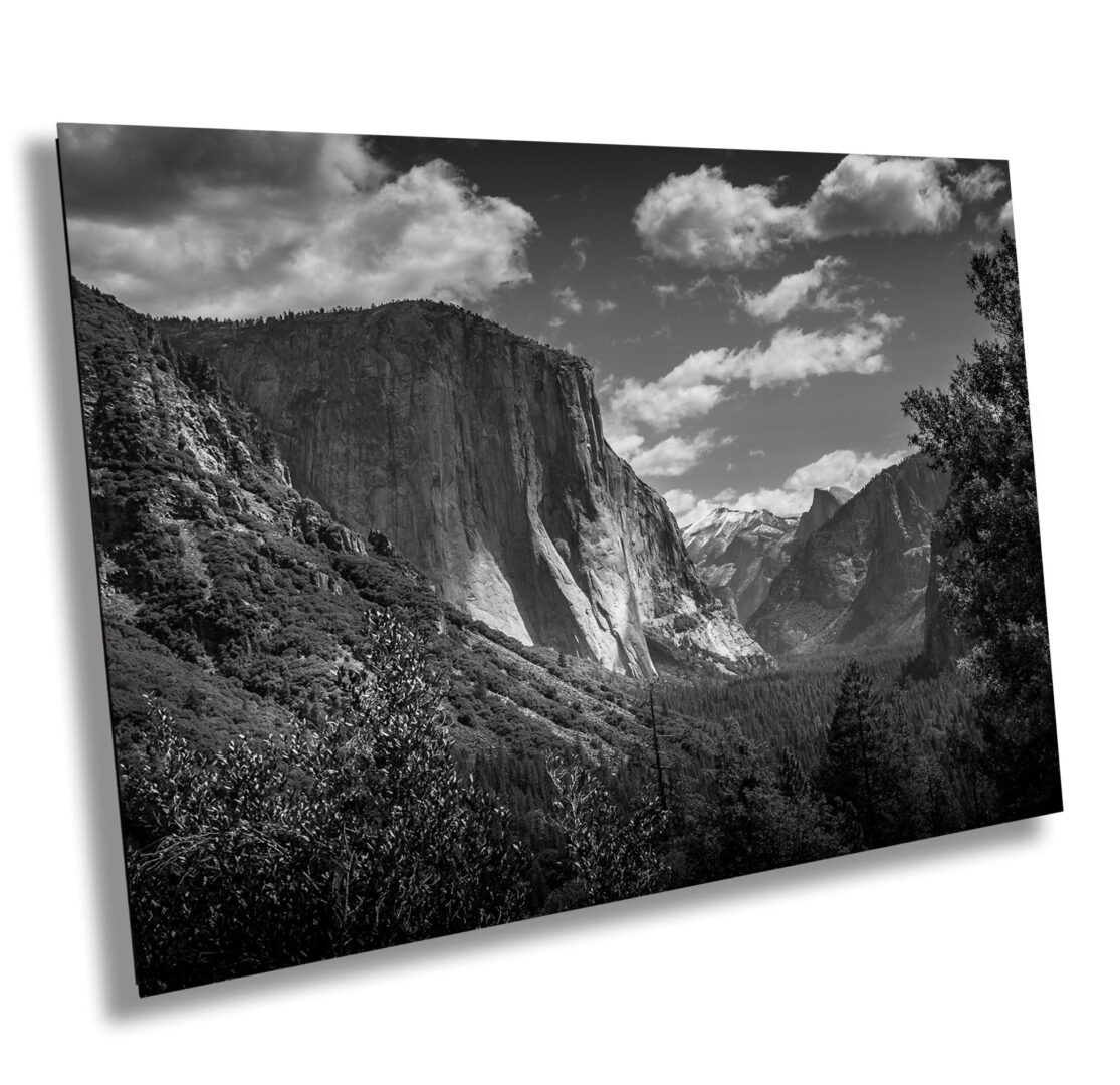 A black and white photo of mountains with clouds in the sky.
