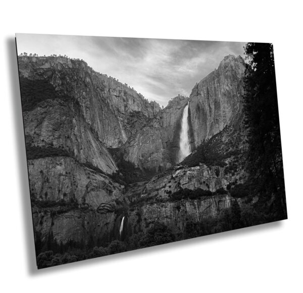 A black and white photo of a waterfall in the mountains.