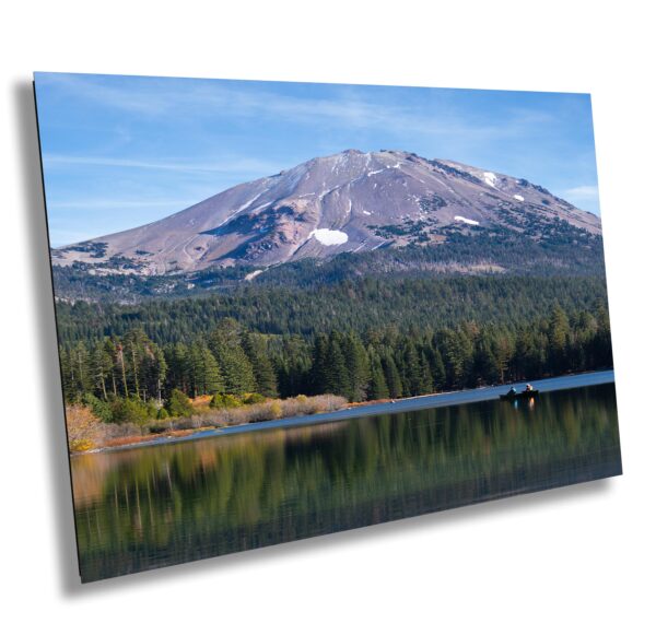 A mountain with snow on top and trees in the foreground.