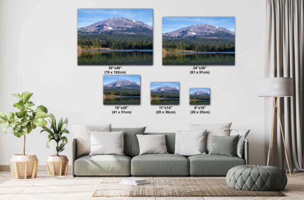 A living room with couch and pillows, and two pictures of mountains.