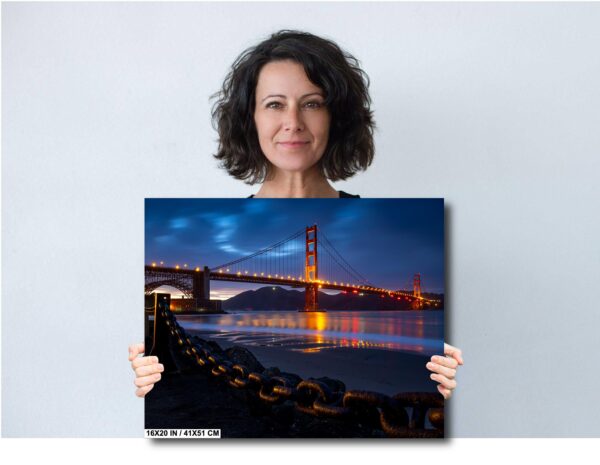 A woman holding up a picture of the golden gate bridge.