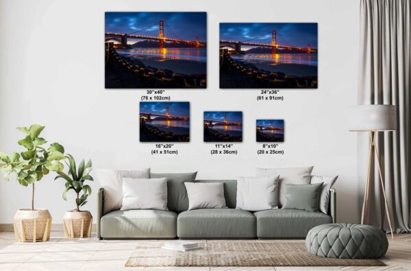 A living room with couch and pillows, and many different sizes of pictures.