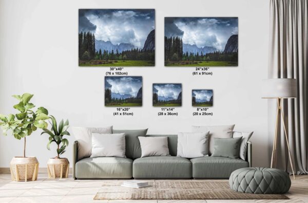 A living room with couch and pillows, and two pictures of mountains.