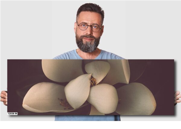A man with glasses and beard standing next to an image of a bunch of bananas.