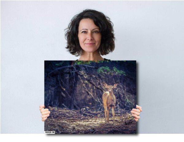 A woman holding up a painting of a deer.