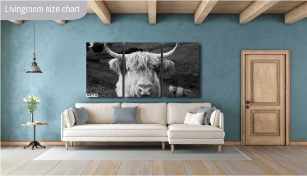 A cow is sitting on the ground in front of a wall.