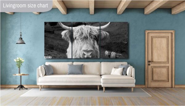 A cow is looking at the camera in this black and white photo.