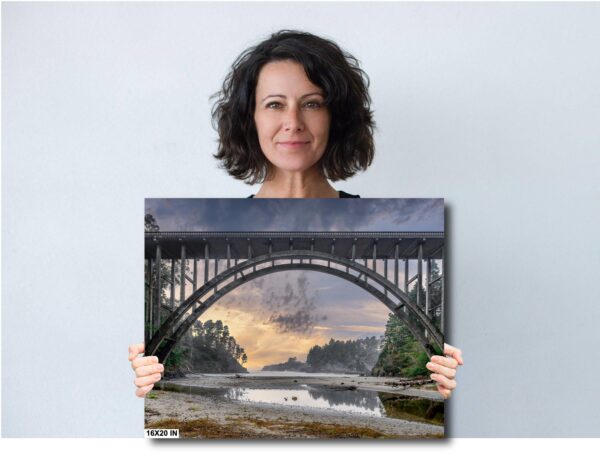 A woman holding up a picture of a bridge