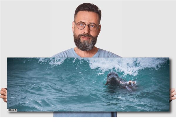 A man holding up a picture of a surfer in the ocean.