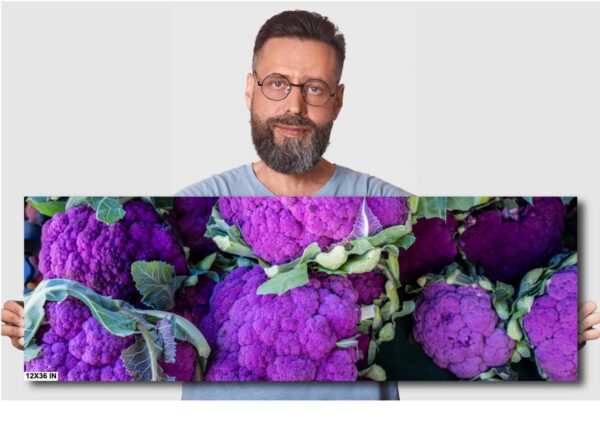 A man is standing in front of some purple flowers
