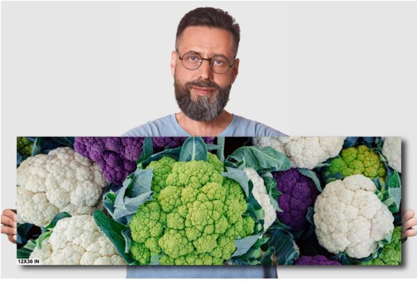 A man with glasses and beard standing in front of cauliflower.