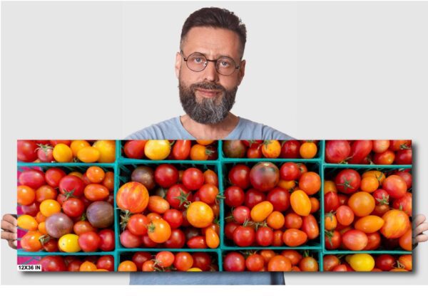 A man with glasses and beard standing in front of boxes filled with tomatoes.
