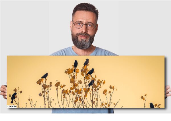 A man is looking at the birds on the flowers.
