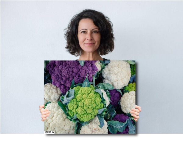 A woman holding up a picture of cauliflower.